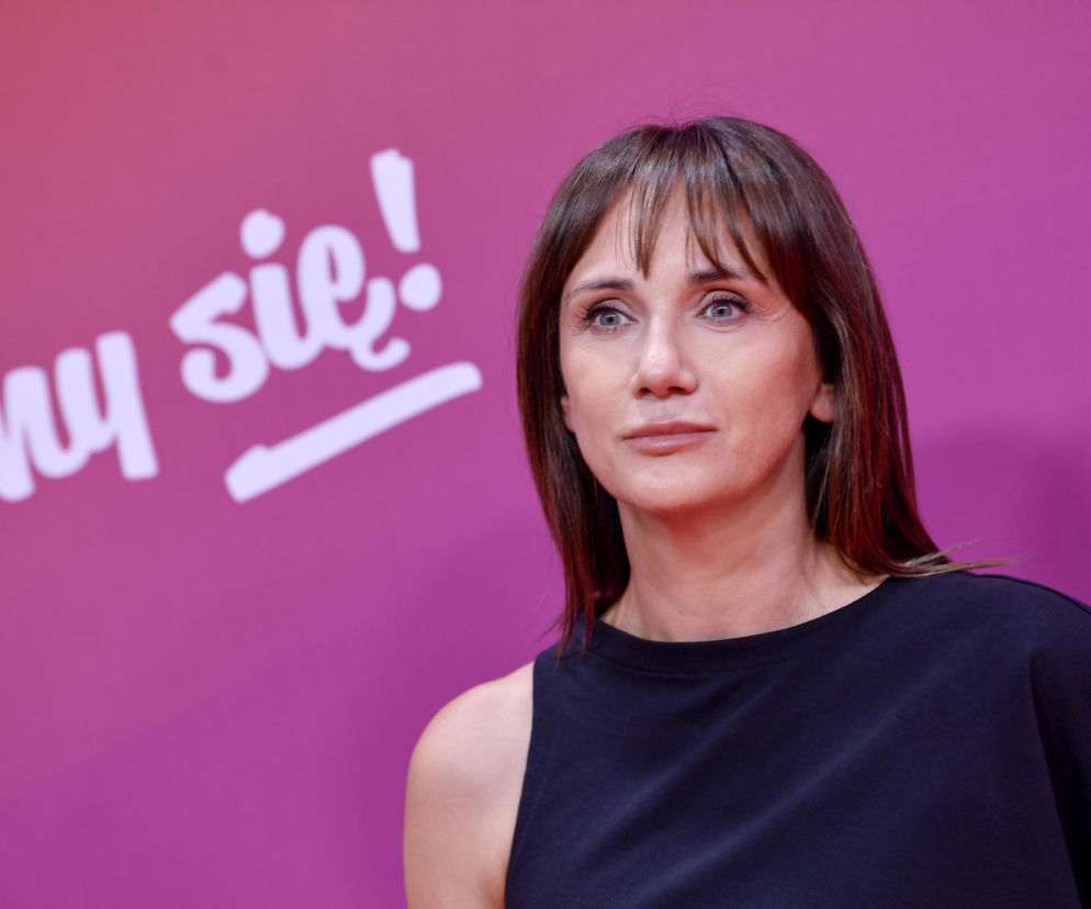 Aktorka Ilona Ostrowska w czarnej bluzce na tle różowej ścianki. O jej przemianie w Ranczo przeczytasz w VOX FM.