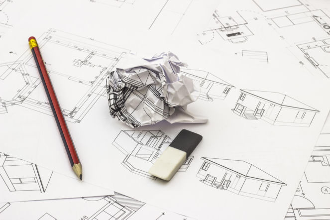 Proces projektowania domu: plany architektoniczne, ołówek i zmięty papier