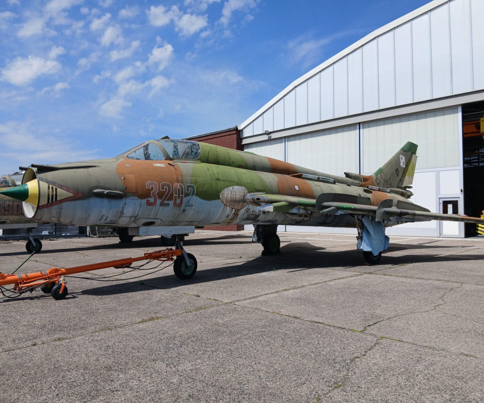 Samolot Su-22 o numerze 3202 na płycie lotniska przed hangarem. O przetargu przeczytasz na SE Portal Obronny.