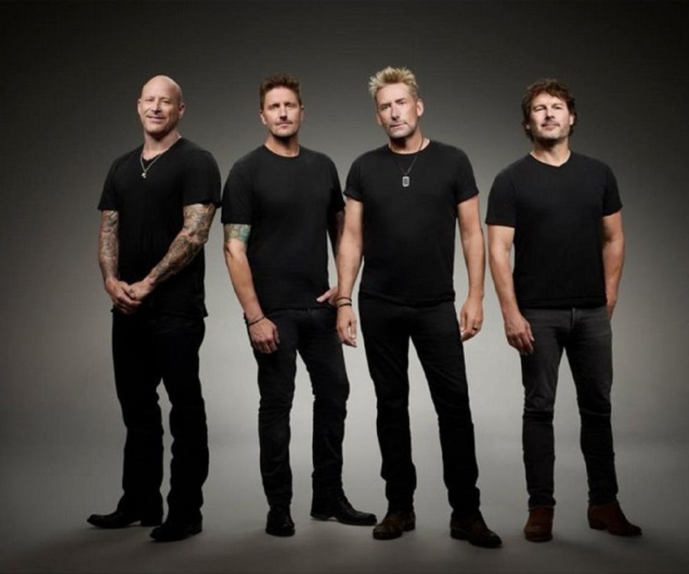 Czterej członkowie zespołu Nickelback w czarnych koszulkach na szarym tle. O nowej płycie przeczytasz na EskaRock.
