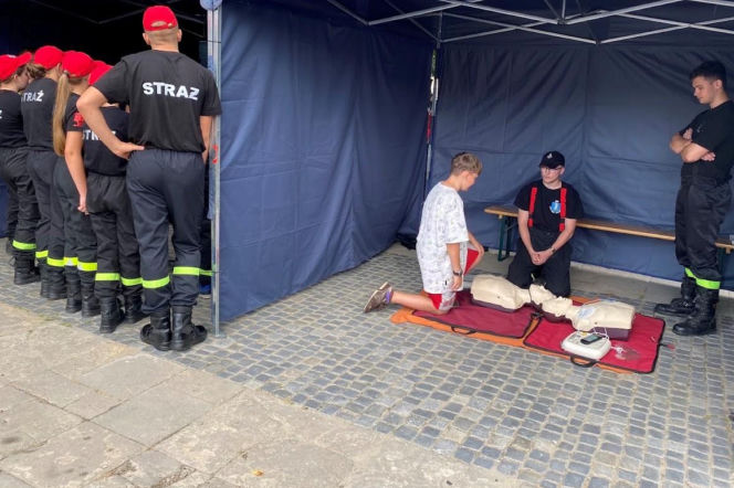 Strażacy uczący chłopca pierwszej pomocy na fantomie. O treningach w Małopolsce przeczytasz na Eska Nowy-Sącz.