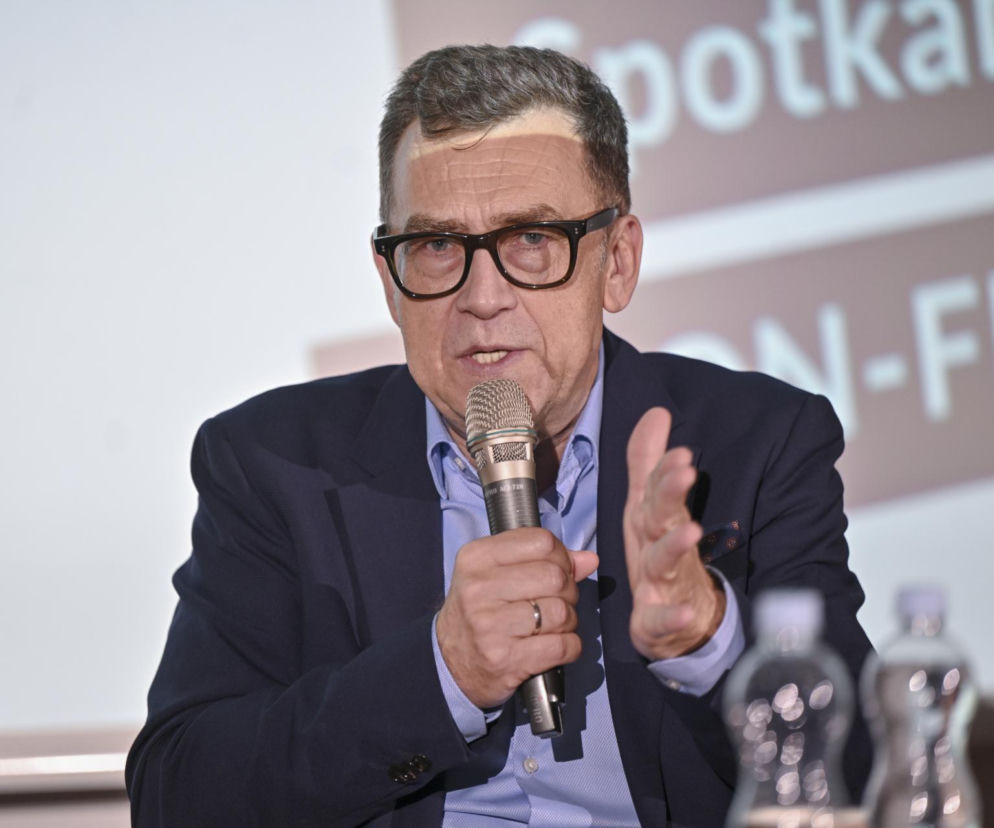 Dziennikarz Maciej Orłoś przemawia do mikrofonu podczas spotkania. O jego emeryturze przeczytasz na VOX FM.