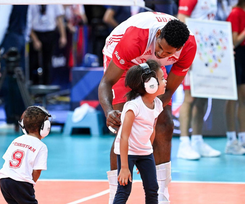 Siatkarz Wilfredo Leon pochylony nad córką Natalią na boisku. Obok synek Christian. O sportowej rodzinie przeczytasz na SE.