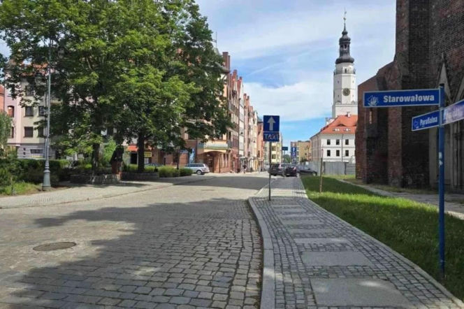 Ulica Parafialna w Głogowie z widocznymi budynkami i drzewami, prowadząca do skrzyżowania. Na horyzoncie widoczna wieża ratusza. Zdjęcie ilustruje zmiany w organizacji ruchu, o których przeczytasz na naszym portalu.