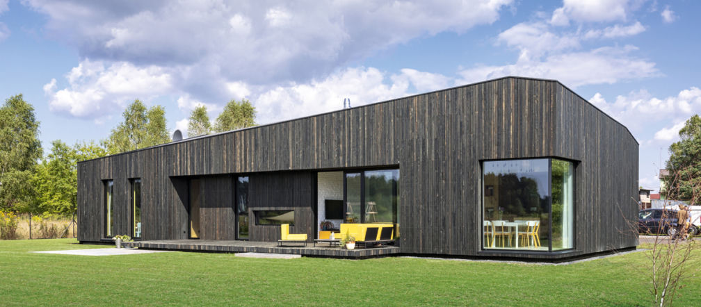 Dom z ciemnym, postarzanym drewnem z modrzewia na elewacji