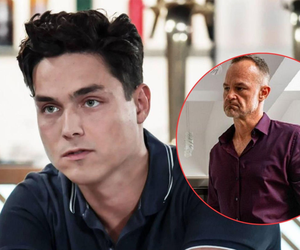 Borys w koszulce polo z widocznym niepokojem na twarzy, obok niego w okręgu mężczyzna w fioletowej koszuli, o spiętej minie, obaj bohaterowie serialu Pierwsza miłość, o którym więcej przeczytasz na Super Seriale.