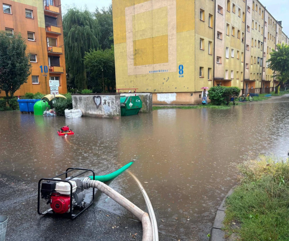 Pompa wypompowuje wodę z zalanej ulicy między blokami w Ostrowie. O skutkach ulewy przeczytasz na Eska Ostrów.