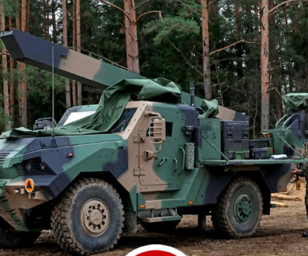 Pojazd systemu GLADIUS w kamuflażu stoi w lesie. Obok żołnierz. O nowym sprzęcie w Suwałkach przeczytasz na Eska Białystok.