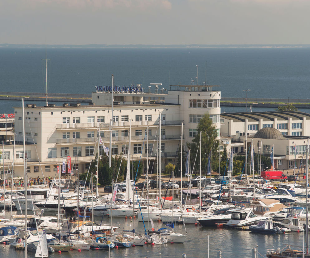 Biały budynek Akademii Morskiej w Gdyni nad brzegiem morza. O modernizmie Gdyni przeczytasz w serwisie Architektura.