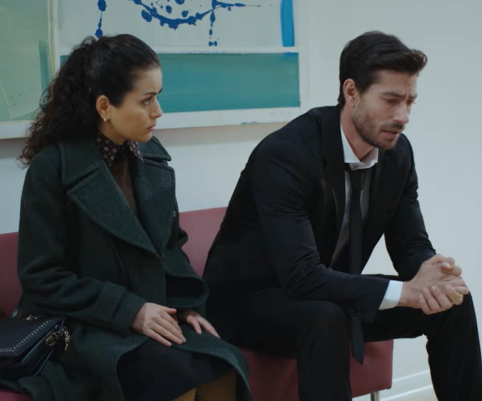 Aynur i Sinan siedzą na kanapie w emocjonalnej scenie z 963. odcinka serialu Dziedzictwo, w której prokurator Sinan wyznaje jej prawdę o śmierci swojego brata. W tle widoczne abstrakcyjne malowidło na ścianie. Więcej o ich losach przeczytasz na naszym portalu.
