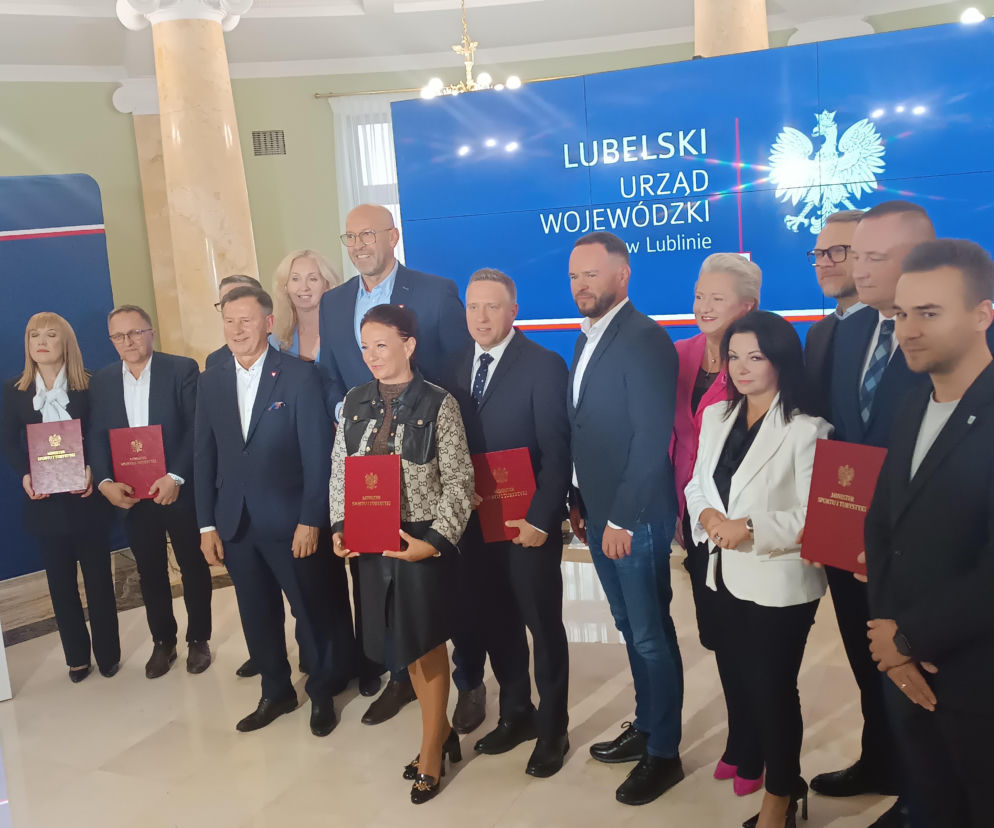Minister Jakub Rutnicki z grupą samorządowców trzymających czerwone teczki. O dotacjach na Orliki pisze Eska Lublin.