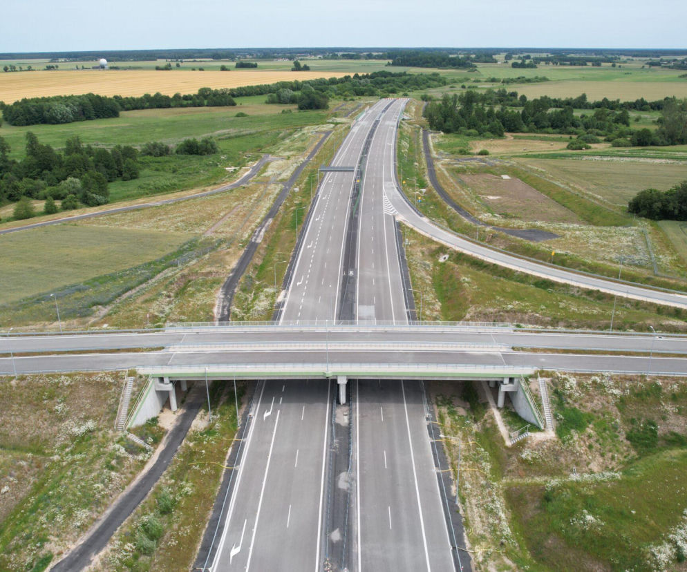 Nowo oddany fragment autostrady A2 między Siedlcami a węzłem Łukowisko, widoczny z lotu ptaka, z wiaduktem nad trasą i otaczającymi ją polami. Więcej o inwestycjach infrastrukturalnych na Architektura Murator Plus.