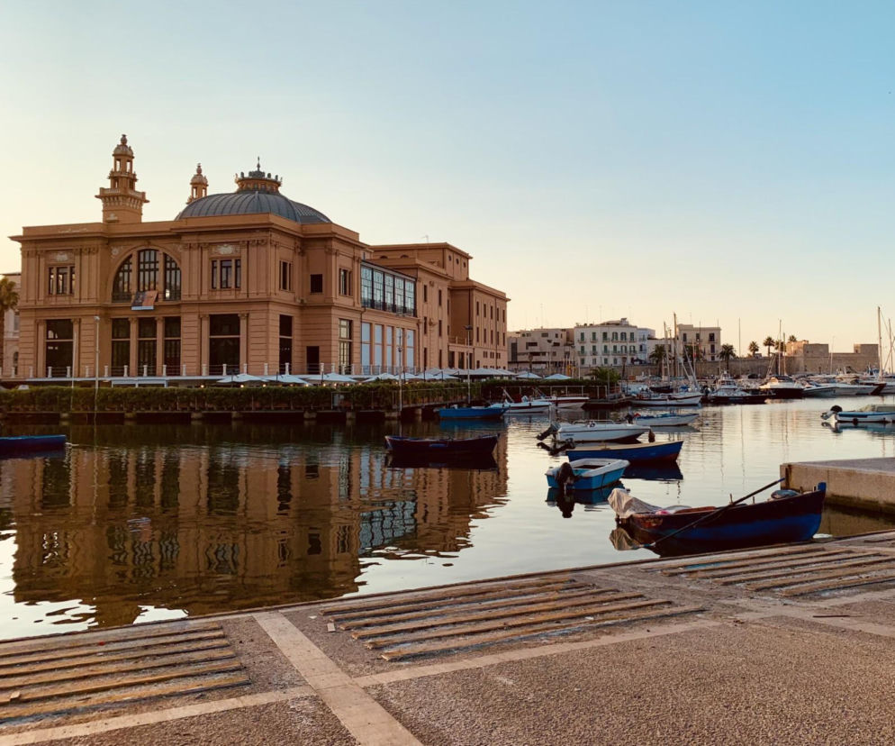 Port w Bari z licznymi łodziami na tle zabytkowego budynku Teatru Margherita. O pamiątkach z Włoch przeczytasz na SE.
