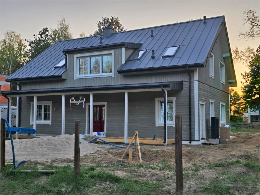 Prefabrykowany dom w Warszawie już z drewnianą okładziną ścian - trwają prace wykończeniowe