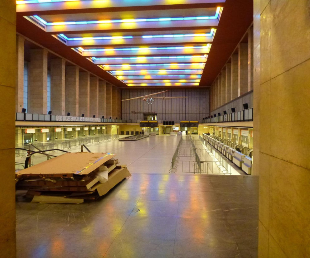 Pusta hala główna lotniska Tempelhof z kasetonowym, kolorowym sufitem. O architekturze tego miejsca przeczytasz w Architektura.