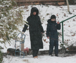 Marta Kaczyńska z synem i psami na sankach w lesie