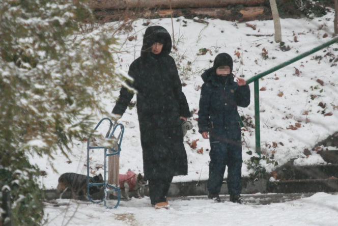 Marta Kaczyńska z synem i psami na sankach w lesie