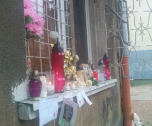 Przed blokiem, w którym zginęła kobieta i dwoje dzieci palą się znicze