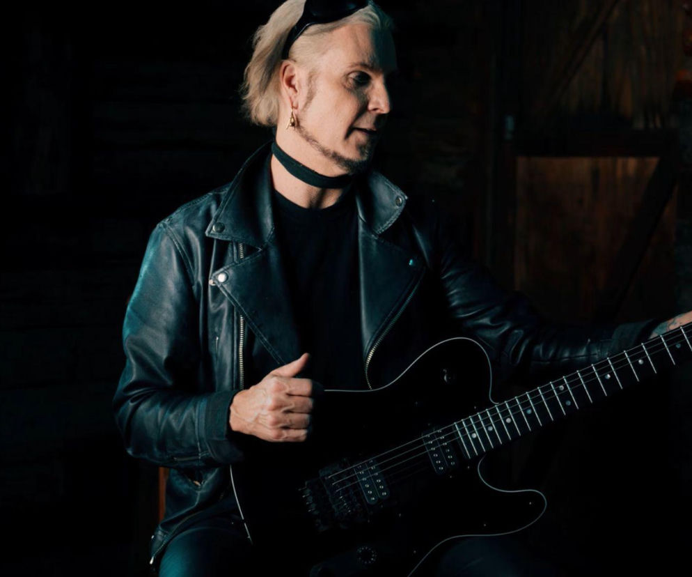 Gitarzysta John 5 w skórzanej kurtce trzyma czarnego Fendera Telecastera. O jego rekordzie przeczytasz na EskaRock.