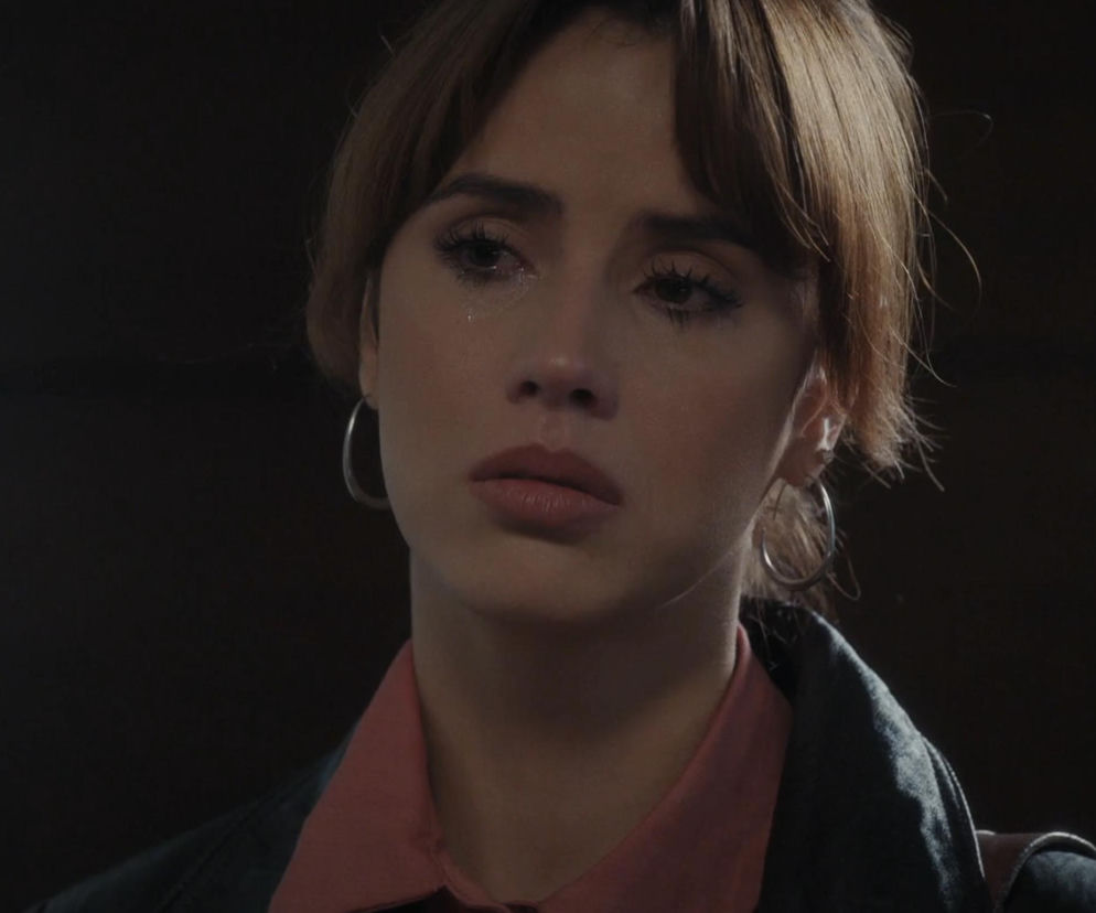 Zbliżenie na twarz Kamy (Michalina Sosna) z serialu M jak miłość, która ma łzy w oczach i smutną minę, symbolizujące jej rozstanie z Marcinem. Ma na sobie różową koszulę i jeansową kurtkę, a jej włosy są ułożone w opadającą na czoło grzywkę. Więcej o dramacie Kamy przeczytasz na Super Seriale.