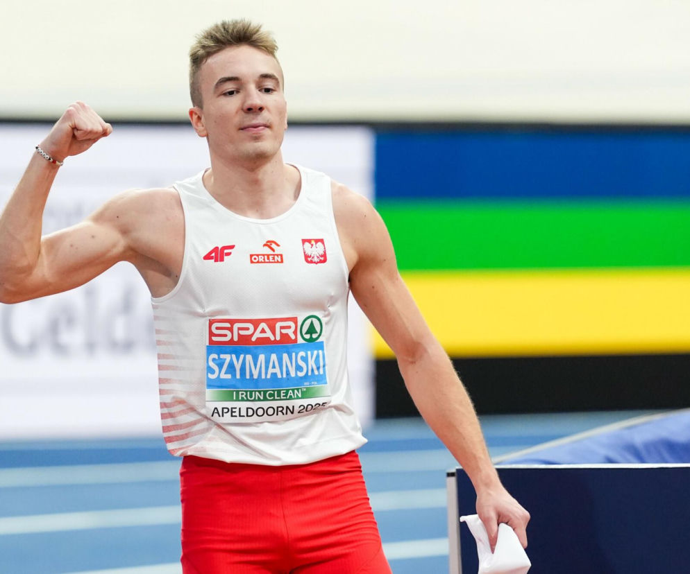 Biegacz Jakub Szymański w białym stroju reprezentacji Polski zaciska pięść. O sukcesie lekkoatlety czytaj w SE Supersport.