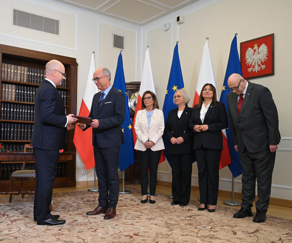Maciej Berek odbiera dokument od Włodzimierza Czarzastego w obecności polityków. O ślubowaniu sędziego przeczytasz w Eska.