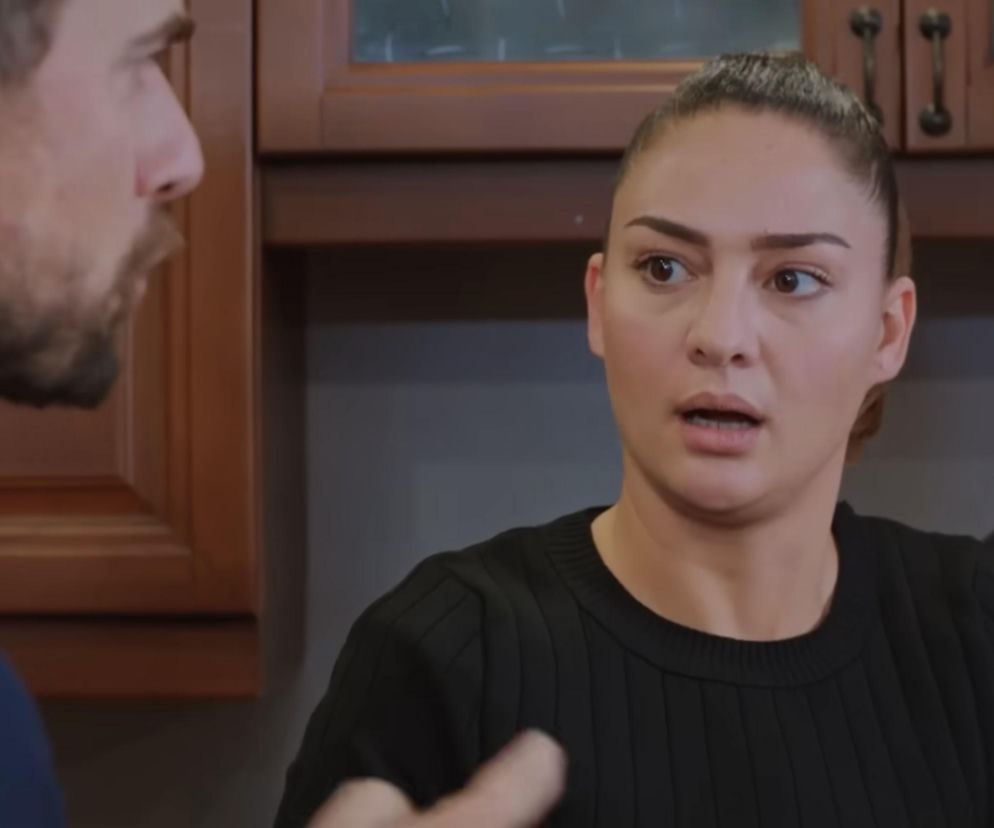 Zaskoczona Yildiz, gosposia z serialu Miłość i nadzieja, stoi w kuchni, a obok niej widać ramię Kuzeya. Kobieta ma zdezorientowany wyraz twarzy, spięte włosy w kucyk. Więcej o ich intrydze przeczytasz na portalu Super Seriale.