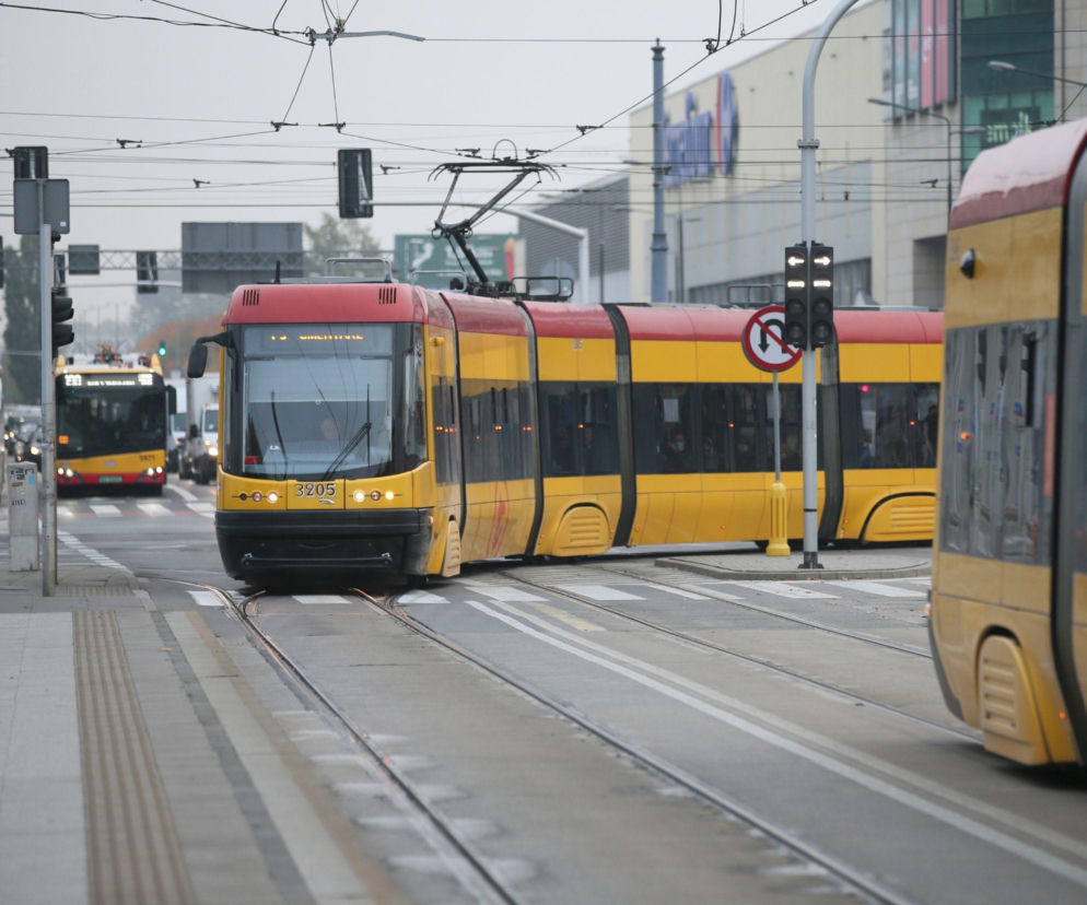 Żółto-czerwony tramwaj jedzie przez skrzyżowanie w mieście. O darmowej komunikacji 1 listopada przeczytasz na SE Superbiz.