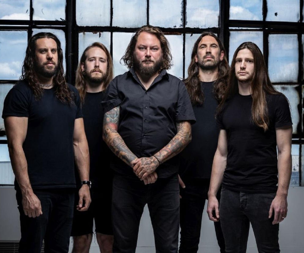 Członkowie zespołu The Black Dahlia Murder pozujący do zdjęcia na tle dużego, kratowanego okna, promujący trasę z okazji dwudziestolecia albumu Nocturnal. O koncercie w Krakowie w 2027 roku i innych wydarzeniach przeczytasz na naszym portalu.