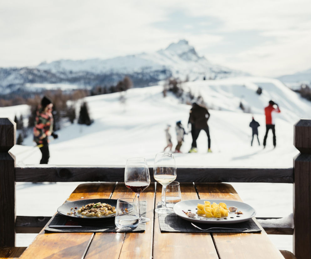 Dania i wino na tarasie z widokiem na ośnieżone Dolomity. O akcji Szusowanie ze smakiem w Alta Badia przeczytasz w Eska.