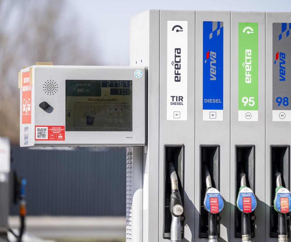 Dystrybutor paliw Orlen z widocznymi cenami za litr, wyświetlaczem z promocją oraz pistoletami do różnych rodzajów paliwa, w tym Efekta 95, Verva Diesel i Verva 98. Obniżka VAT na paliwa może pomóc polskim kierowcom, o czym przeczytasz na Super Biznes.