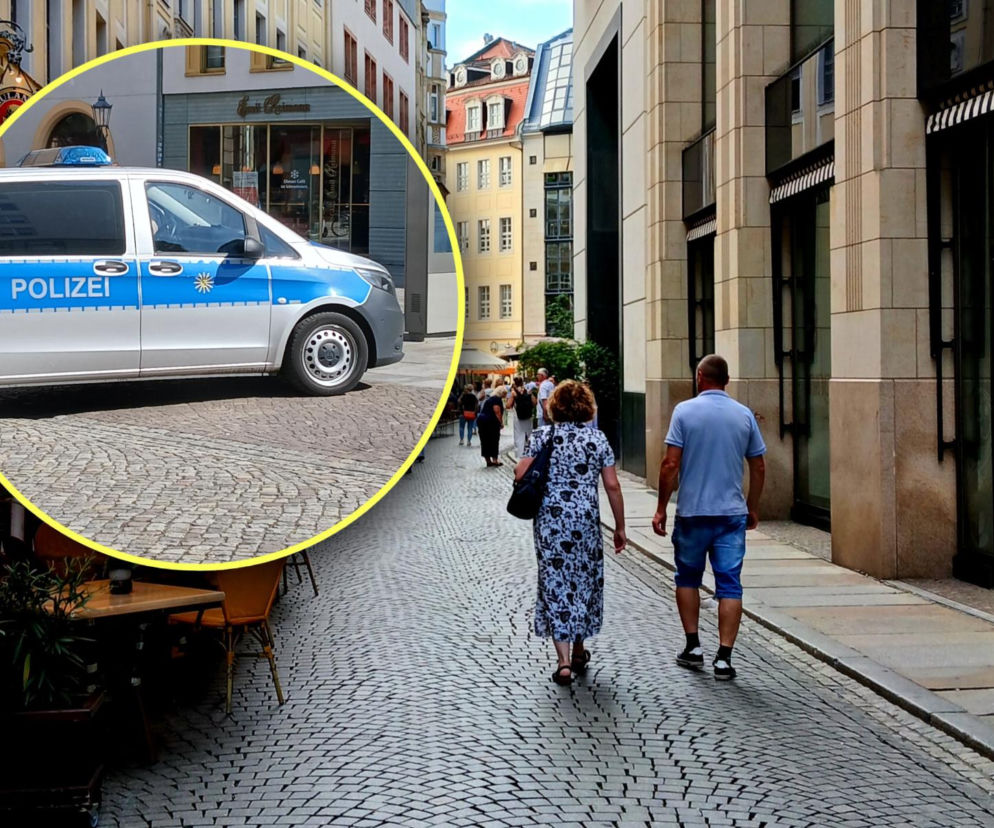Para idzie brukowaną uliczką w Lipsku. Na miniaturze radiowóz niemieckiej policji. O deportacji Polaków przeczytasz w SE.