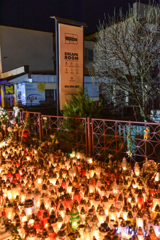 Tragedia w escape roomie. Modlący się ludzie, światła, kwiaty i zabawki pozostawione w miejscu tragedii.