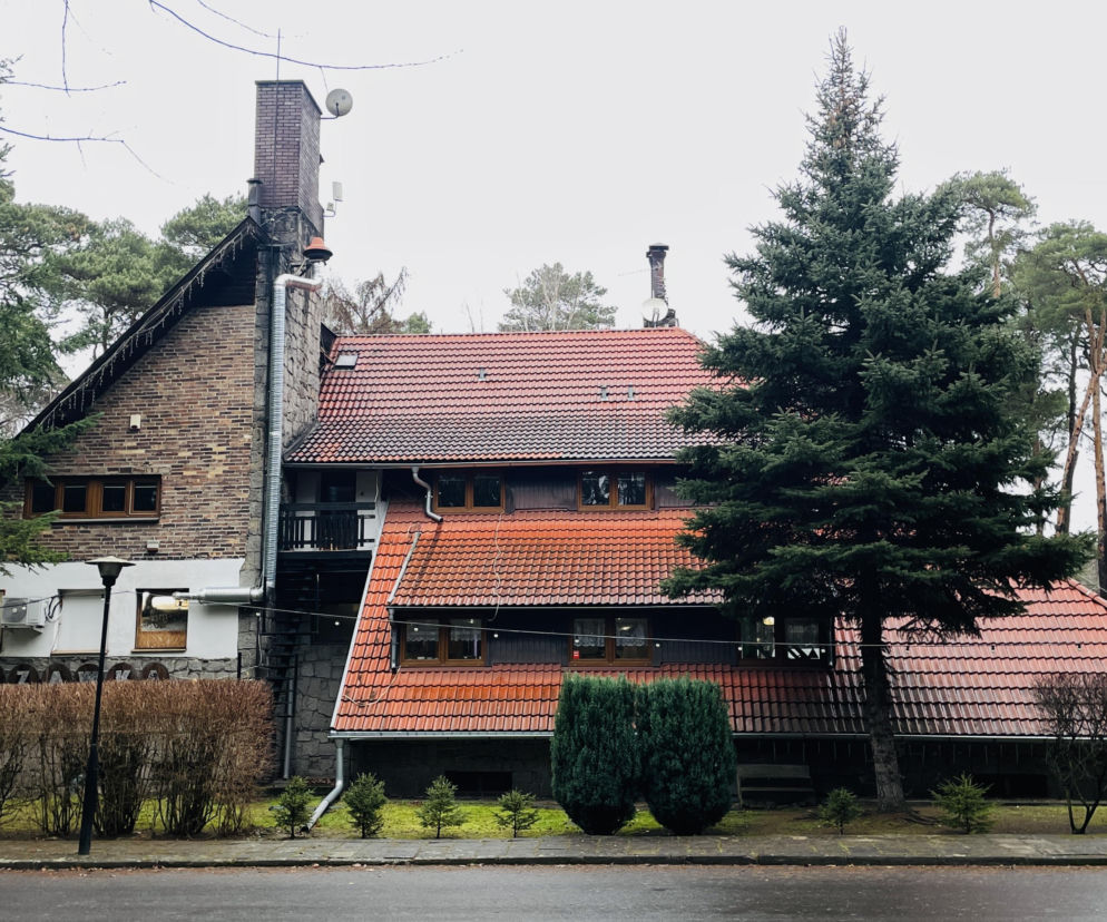 Murowany gościniec Lizawka ze spadzistym czerwonym dachem w lesie. O tych wyjątkowych zajazdach przeczytasz w Architektura.