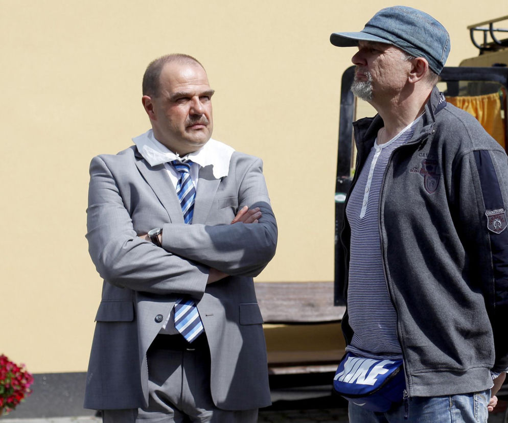 Aktor Cezary Żak w roli wójta i prezydenta Piotra Kozioła oraz reżyser Wojciech Adamczyk na planie serialu Ranczo. Zdjęcie ilustruje kontrowersje wokół nowego sezonu, o których przeczytasz więcej na portalu Super Seriale.
