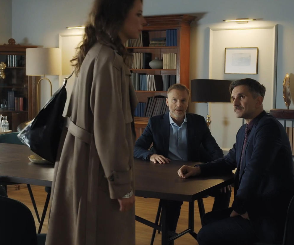 Paulina Lipska, w płaszczu i z torebką, opuszcza kancelarię, przy stole siedzą Kamil Gryc i Andrzej Budzyński, dyskutując o planie wsadzenia Jabłońskiego za kratki w serialu „M jak miłość”. O dalszych losach bohaterów przeczytasz na portalu Super Seriale.