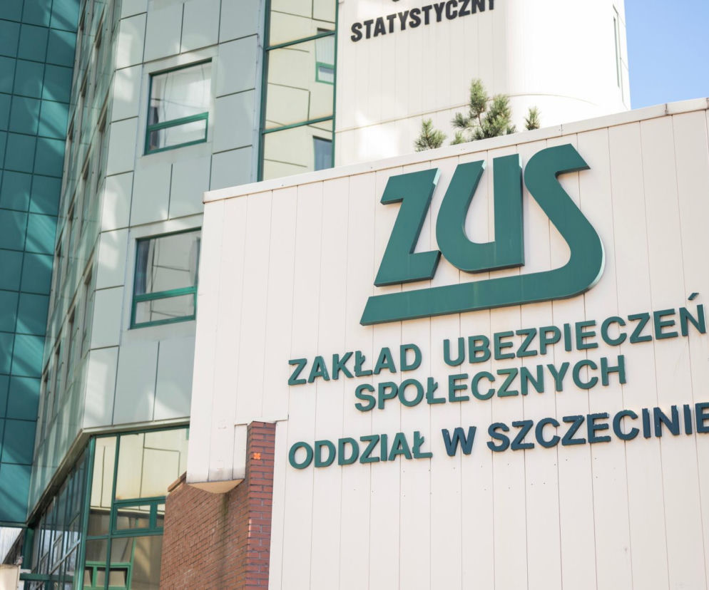 Budynek ZUS w Szczecinie z zielonymi napisami ZUS Zakład Ubezpieczeń Społecznych Oddział w Szczecinie na białej fasadzie, obok nowoczesny szklany biurowiec. Temat istotny dla seniorów, o czym więcej przeczytasz na Super Biznes.