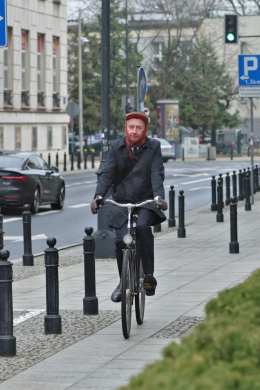 Maciej Gdula na rowerze. Chroni uszy przed chłodem