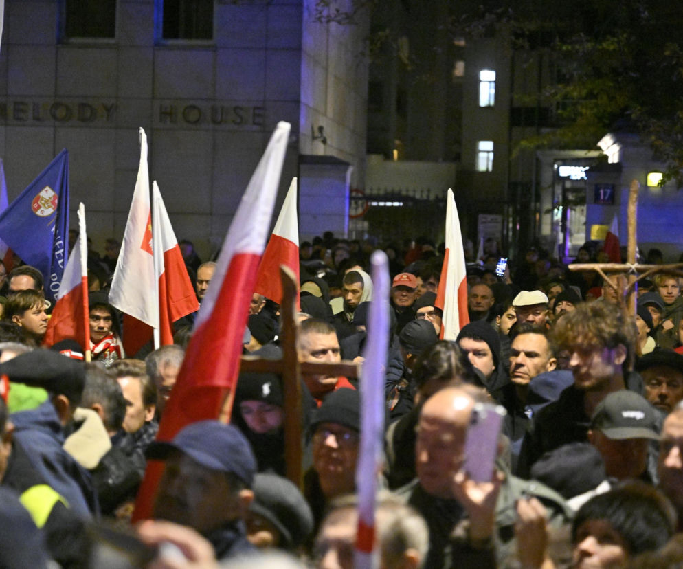 Tłum ludzi z polskimi flagami przed gmachem w nocy. O kryzysie wokół Trybunału Konstytucyjnego przeczytasz w VOX FM.