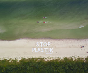 Wielki napis Stop plastik na plaży w Kołobrzegu