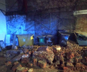 Runął zabytkowy mur na Bednarskiej. Uszkodził kilka aut i kontenery śmietnikowe