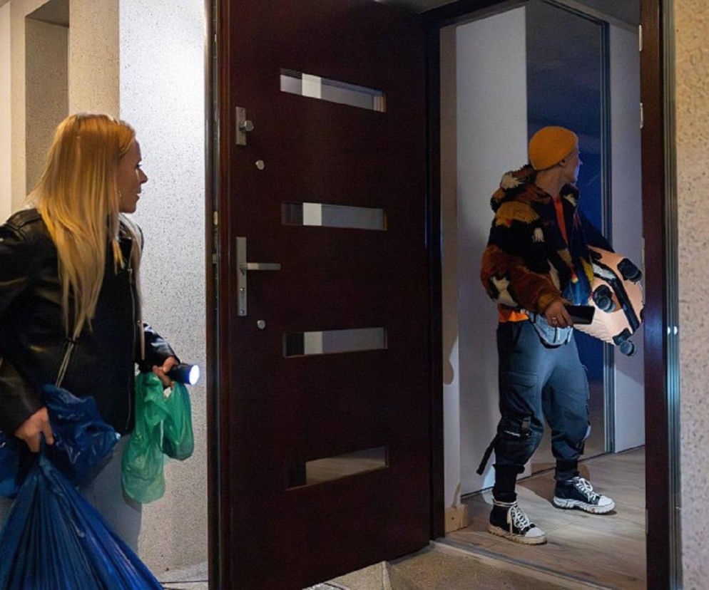 Dominika i Karma (Monika Dawidziuk) z serialu Pierwsza miłość dokonują włamania do domu Izabeli, wchodzą przez otwarte drzwi. Kobieta z latarką w ręku trzyma foliowe torby, podczas gdy mężczyzna, również z latarką, ciągnie małą walizkę. Więcej o ich losach na Super Seriale.