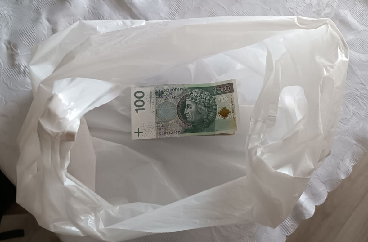 Uwierzyła oszustom, straciła oszczędności życia. Seniorka spakowała pieniądze w reklamówkę i wywiesiła je za drzwiami mieszkania