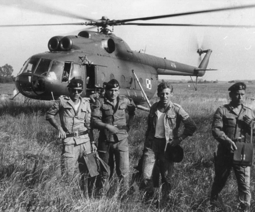 Czterech komandosów w beretach stoi na trawie przed śmigłowcem Mi-8. O inwazji z 1968 roku przeczytasz na SE Portal Obronny.