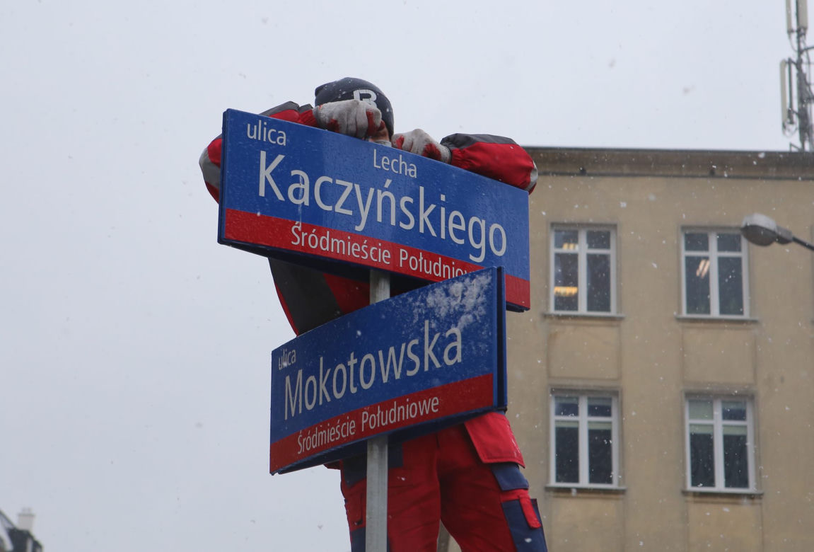 Dekomunizacja Warszawy. Zdejmowanie tablicy z Aleją Lecha Kaczyńskiego, zakładanie na powrót Armii Ludowej.