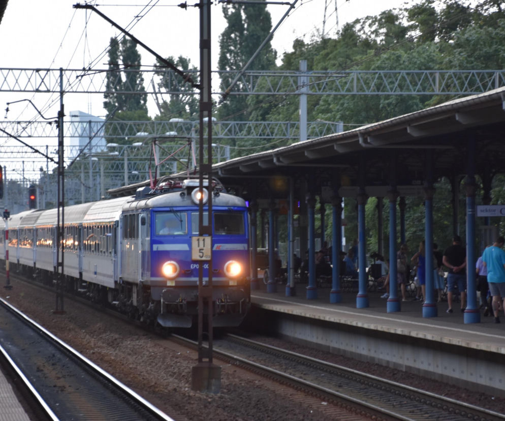 Pociąg PKP Intercity wjeżdżający na stację, obok peron z oczekującymi pasażerami. Scena symbolizująca utrudnienia i opóźnienia w ruchu kolejowym po wypadku w Białośliwiu, o których przeczytasz więcej na naszym portalu.