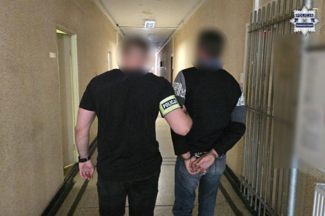 Policjant prowadzi zakutego w kajdanki kierowcę ciężarówki. O zatrzymaniu na Śląsku przeczytasz na Eska Śląskie.