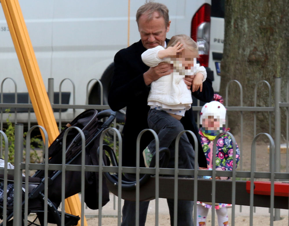 Donald Tusk z wnuczka na placu zabaw
