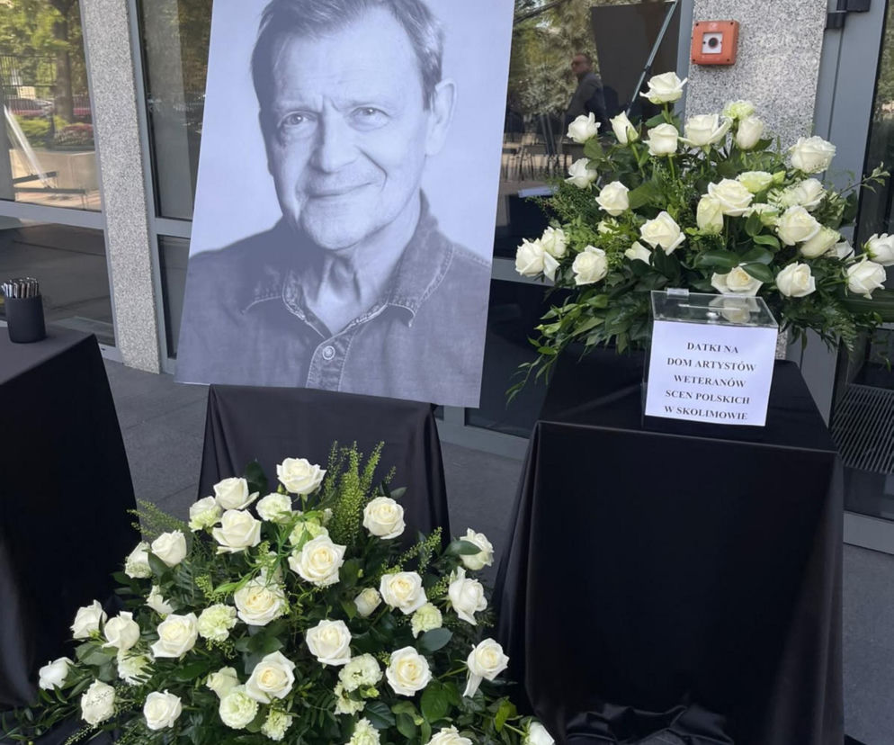 Portret Jana Frycza obok białych róż i puszki na datki dla Skolimowa. O pogrzebie aktora przeczytasz na SE.