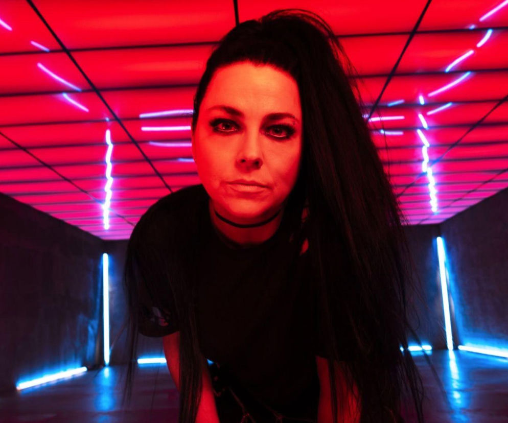 Amy Lee z Evanescence na tle czerwonych i niebieskich świateł. O historii piosenki przeczytasz na EskaRock.